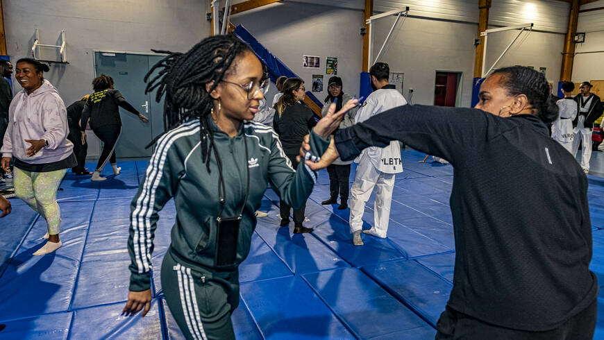 Black woman practicing self-defense in a supervised martial arts class